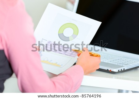 Close up on hands holding pen and document with graphic