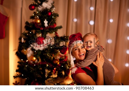 Portrait of smiling young mother with beautiful baby  near Christmas tree