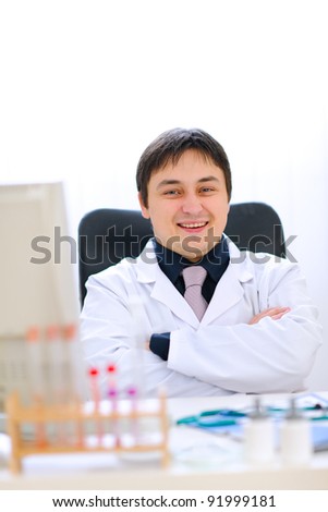 Portrait of smiling medical doctor sitting in cabinet