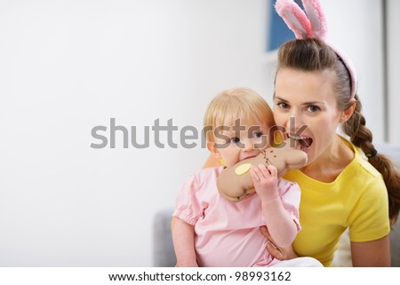 Mother and baby biting chocolate Easter rabbit cookie