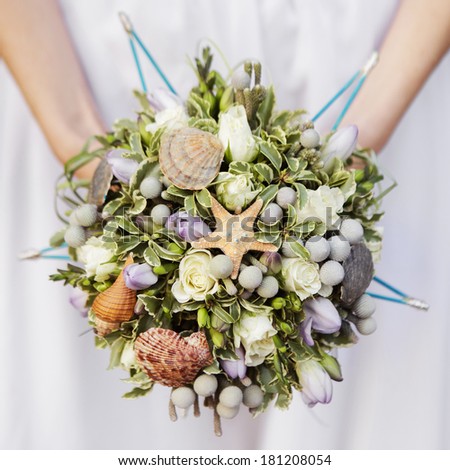 wedding bouquet of beige roses and leaves decorated with shells