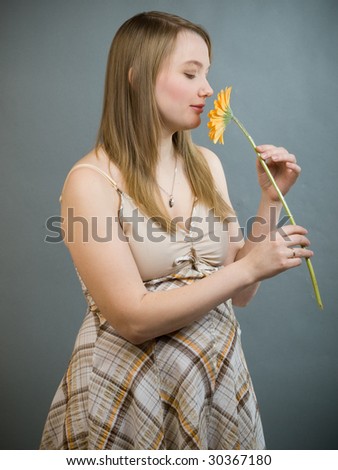young pregnant woman smelling yellow flower