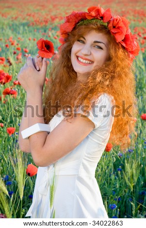 young redheaded girl in poppies field
