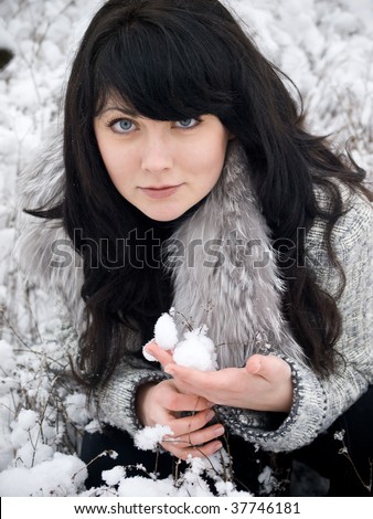 young woman in fur coat outdoors in snow garden