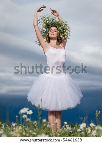 large step of beautiful ballet dancer against cloudy sky