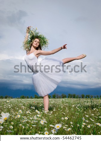 large step of beautiful ballet dancer against cloudy sky