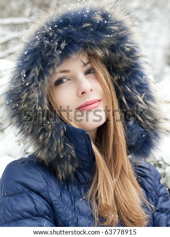 smiling young woman in blue coat outdoors