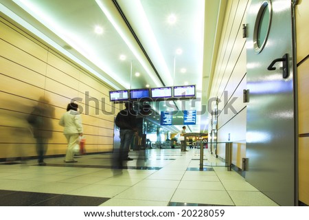 People mooving in hall corridor with tv displays in airport