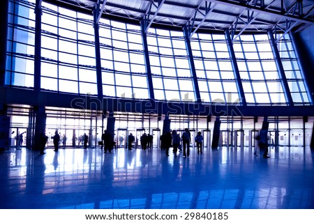 People in wide violet enter hall window in exposition center, left copmosition