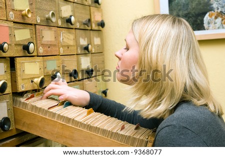 Young student girl working with library card index