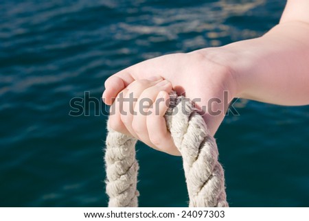 Woman`s hand holding a thick rope