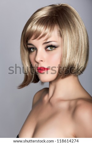 beautiful blond young woman wearing short bob hairstyle on studio background