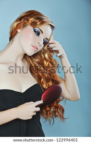 beautiful woman brushing long curly red hair over her shoulder Ã?Â¢?? focus on the hair