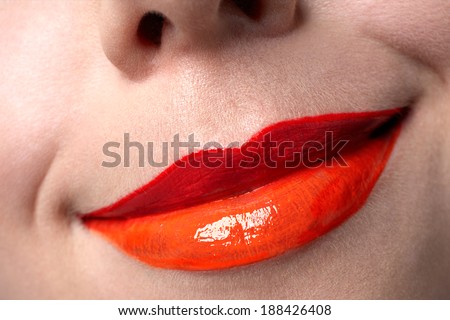 closeup of woman'??s red coral and orange colour lips on clear skin