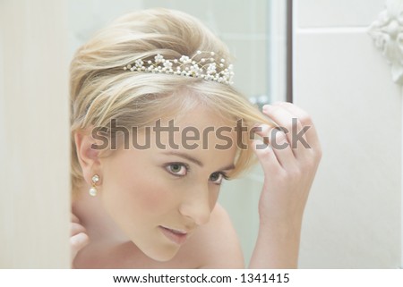 Reflection of a young bride fixing her hair