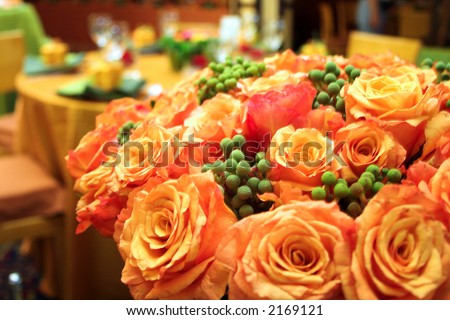 Orange roses in a lush bouquet in a wedding reception venue