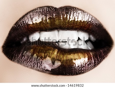 Woman biting her lips with black glossy lipstick and gold powder shine