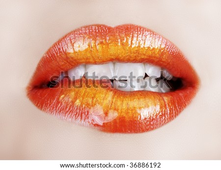 woman biting lip with gold orange lipstick
