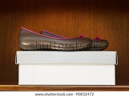 pair of brown plastic shoes on a box on the shelf in the shop