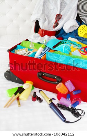 Travel suitcase packed for woman vacation with personal belongings. Concept. Preparation for holidays in sea resort: what to pack to the luggage.