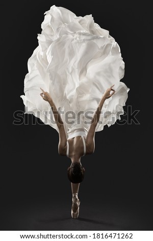 Ballerina Graceful Jump in White Silk Dress, Ballet Dancer Pointe Shoes in Fluttering Cloth, Black Background