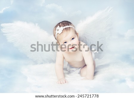Baby Newborn with Angel Wings. Child Sitting at Blue Sky Cloud. Artistic Fantasy Sky Background.