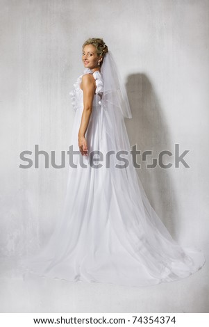 Bride in wedding white long empire style dress. Smiling at camera. Full length