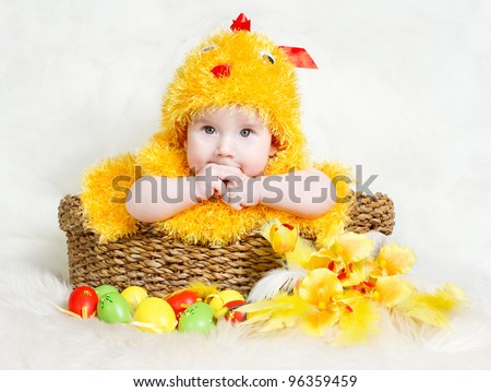 Baby in Easter basket with eggs in chicken costume. Easter holiday concept: nest with baby chick