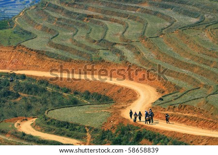 Traveler and hmong villager walk at Curve Dirt road in sapa with and paddle rice field