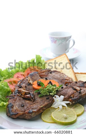 closeup of T Bone Pepper Steak dressing by vegetable and bread  with Coffee cup