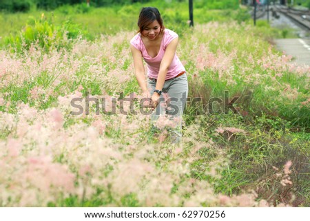 a south east asian girl in pink blouse with hat in flower and grass garden