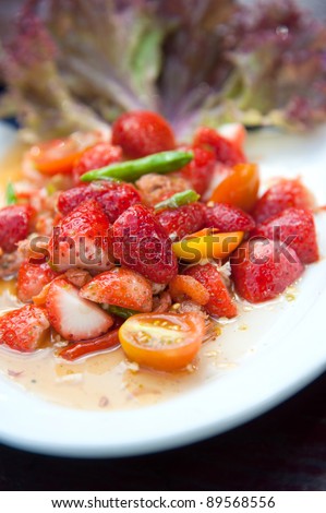 Strawberries spicy salad with chili, tomatoes and green vegetables