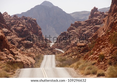 A highway rolling through red rock canyons in Nevada