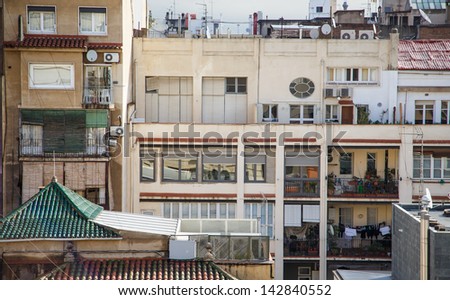 Back of homes in Barcelona with balconies covered with plants, furniture and laundry