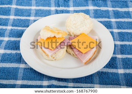 Two ham and cheese biscuits on a white plate