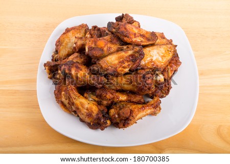 Fried chicken wings with mesquite sauce on a white plate