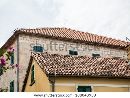 Two old stone buildings in Kotor, Montenegro with clay pipe roofs