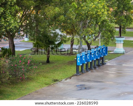 Row of old blue telephone kiosks in a tropical park