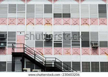 Black iron stairs on an old pink and white building in the Bahamas