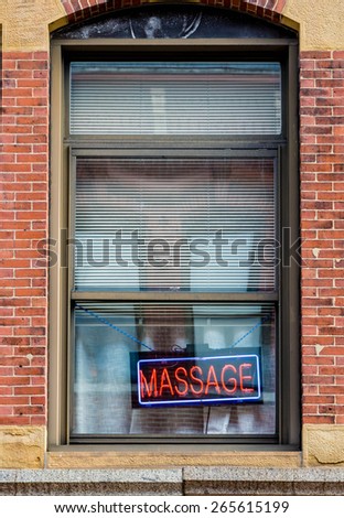 Red and blue neon sign in the window of a massage parlor