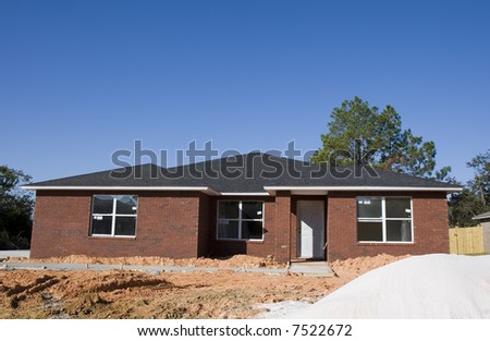 New brick home construction with a pile of sand in front
