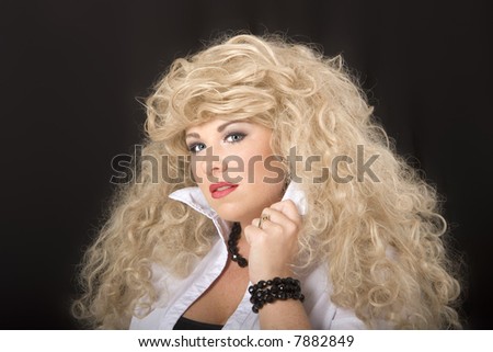 A model with blonde wig holding collar and looking into camera