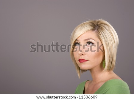 A blonde model in green blouse looking up and to the side