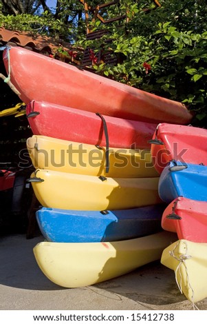 Stacks of red yellow and blue kayaks