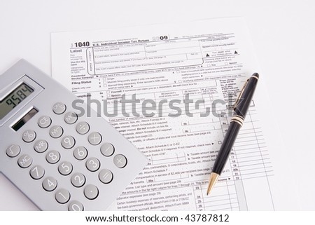 A 2009 U.S. Income Tax form with a pen and a calculator