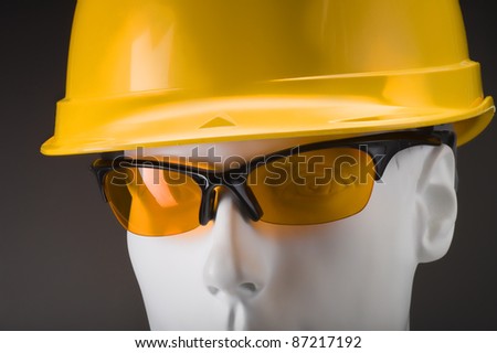 white dummy head with yellow security helmet and glasses