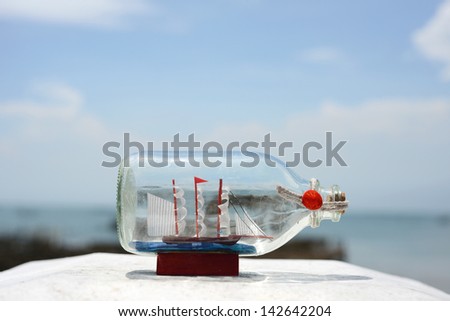 sail ship model in glass bottle with summer sea background