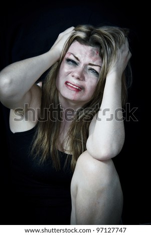 STOP Violence With Women, Scared white woman holding her head in pain with a black background