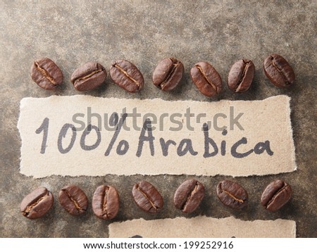 Coffee crop beans with 100 percent arabica  paper on wood texture background
