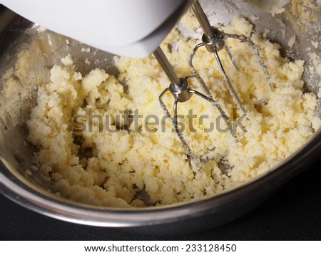 Mixing butter and sugar in bowl with mixing machine, making bakery